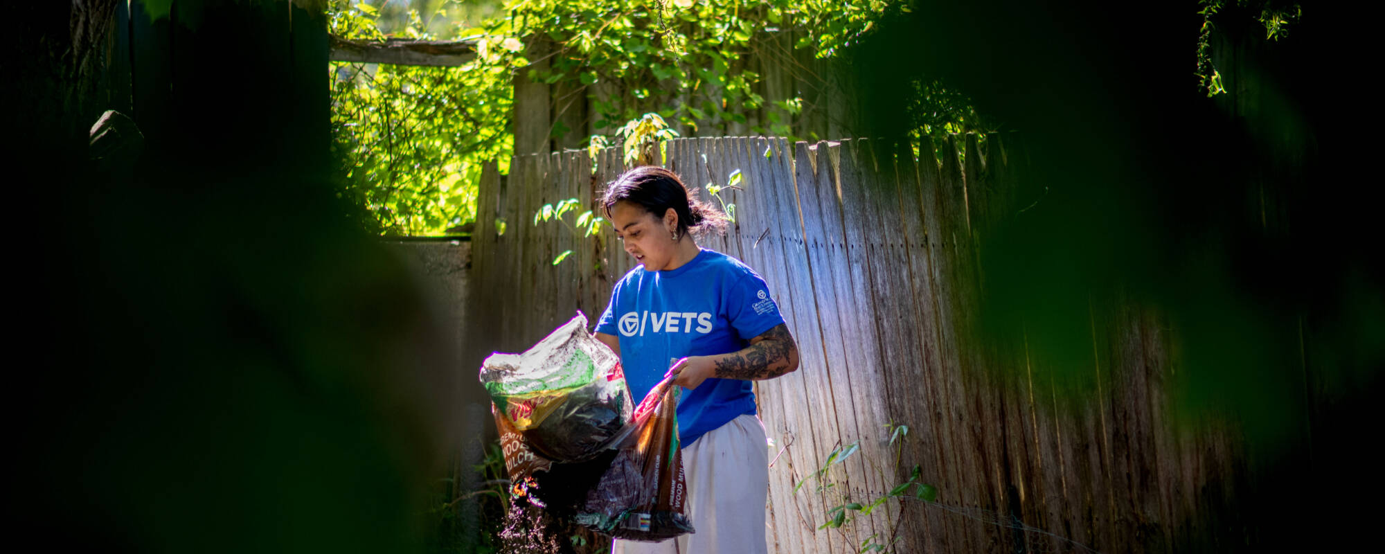 Student volunteer Alex-Mari Ford works on spreading mulch behind a Grand Rapids home during Operation United. Ford is a senior studying allied health sciences and serves on student senate.